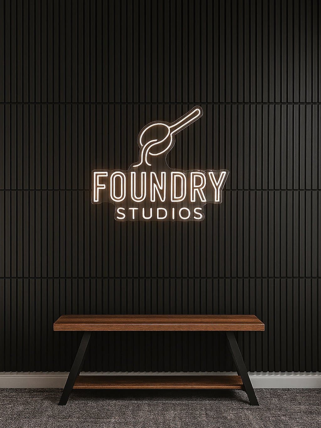 The Foundry Studios neon sign above a wooden bench